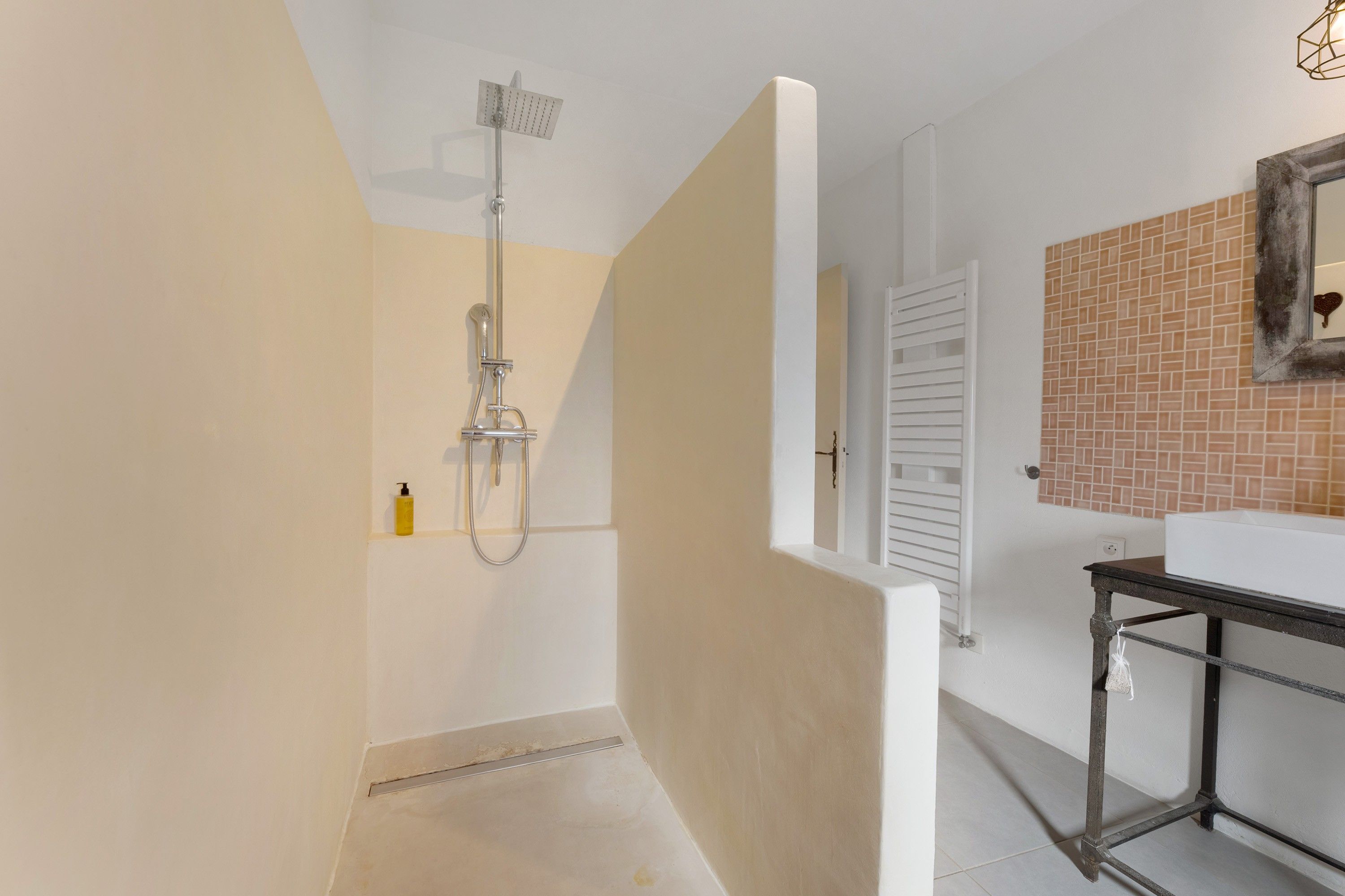 A modern bathroom with a shower, a toilet, and a sink.