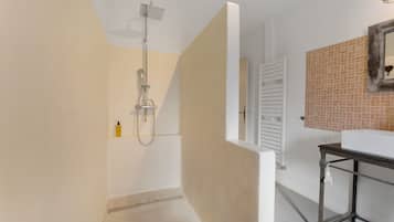 A modern bathroom with a shower, a toilet, and a sink.