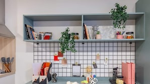 A workspace with a desk, shelves, and a tiled wall. - Student Only The Brook (Bath)