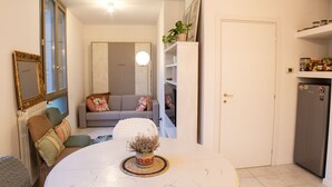En kompakt bolig med spisebord, sofa og køleskab.