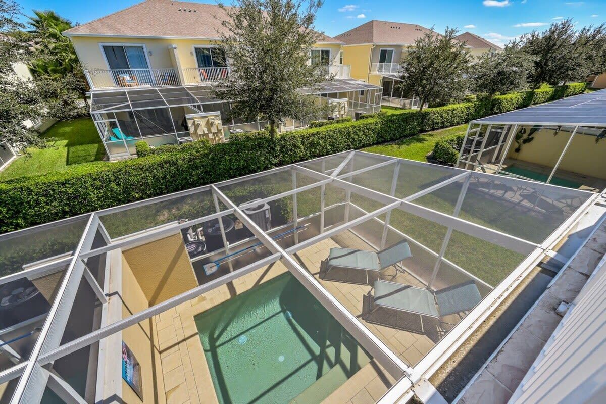 Un barrio residencial con piscina, un patio cubierto y casas con balcones.