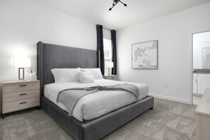 Um quarto moderno com uma cama, mesas de cabeceira e um criado-mudo.