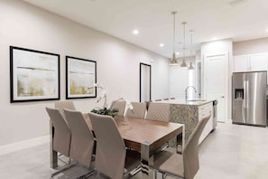 A modern kitchen with a central island, stainless steel appliances, and pendant lighting.