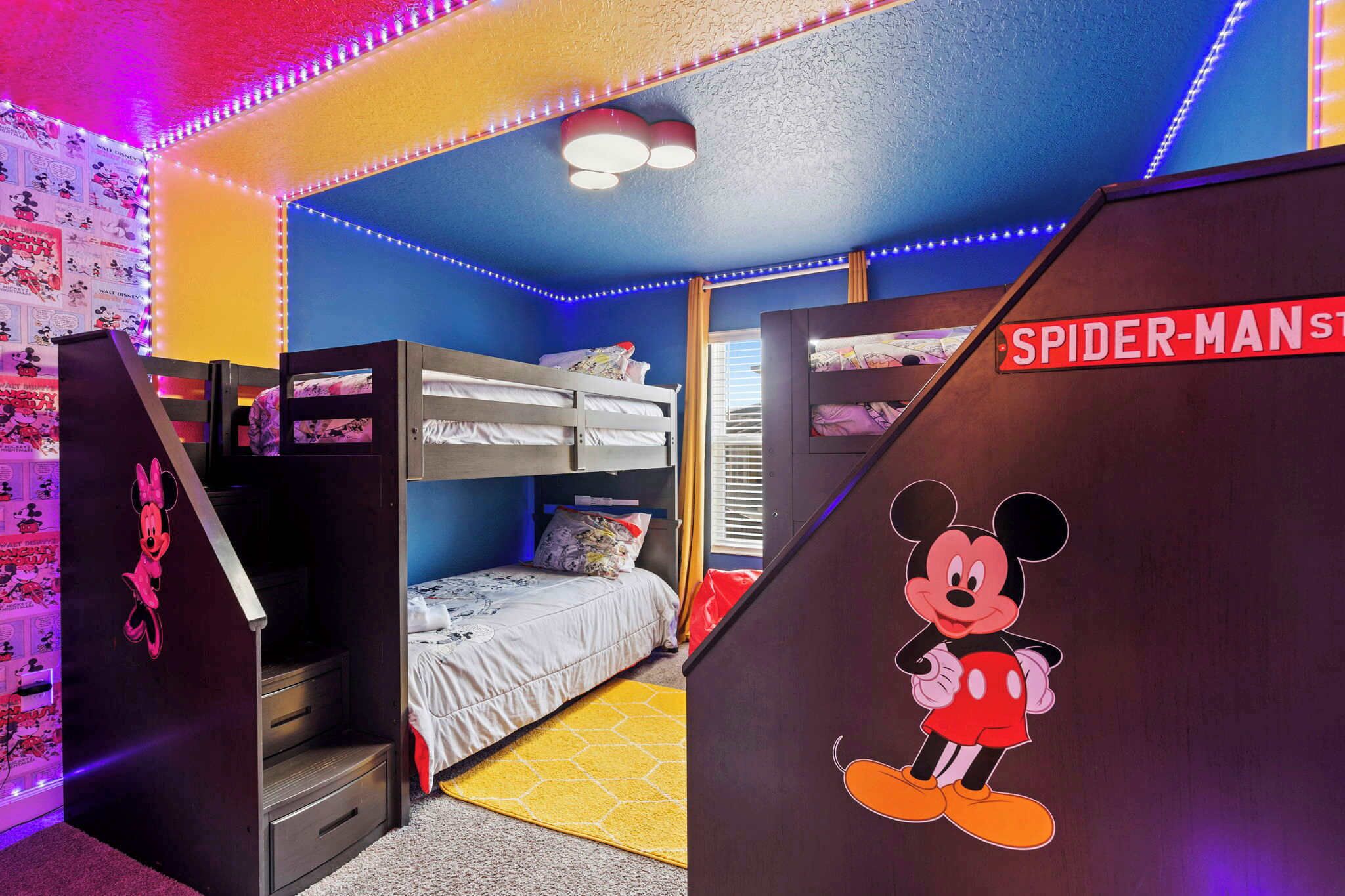 Une chambre avec des lits superposés, une découpe de Mickey Mouse et une affiche de « Spider-Man ».