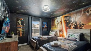 A room with two beds, Star Wars posters, a galaxy-themed ceiling, and a Star Wars mural on the wall. - Chic 4BR Home With Mickey & Star Wars Rooms (Davenport)