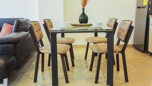 A dining area with a table, chairs, a vase, and a refrigerator. - Premium Three Bedroom Apartment at Clifton Place (Accra)