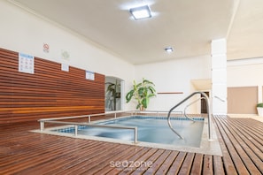 Et poolområde med træterrasse, metalgelændere og et skilt, der angiver at svømning ikke er tilladt.