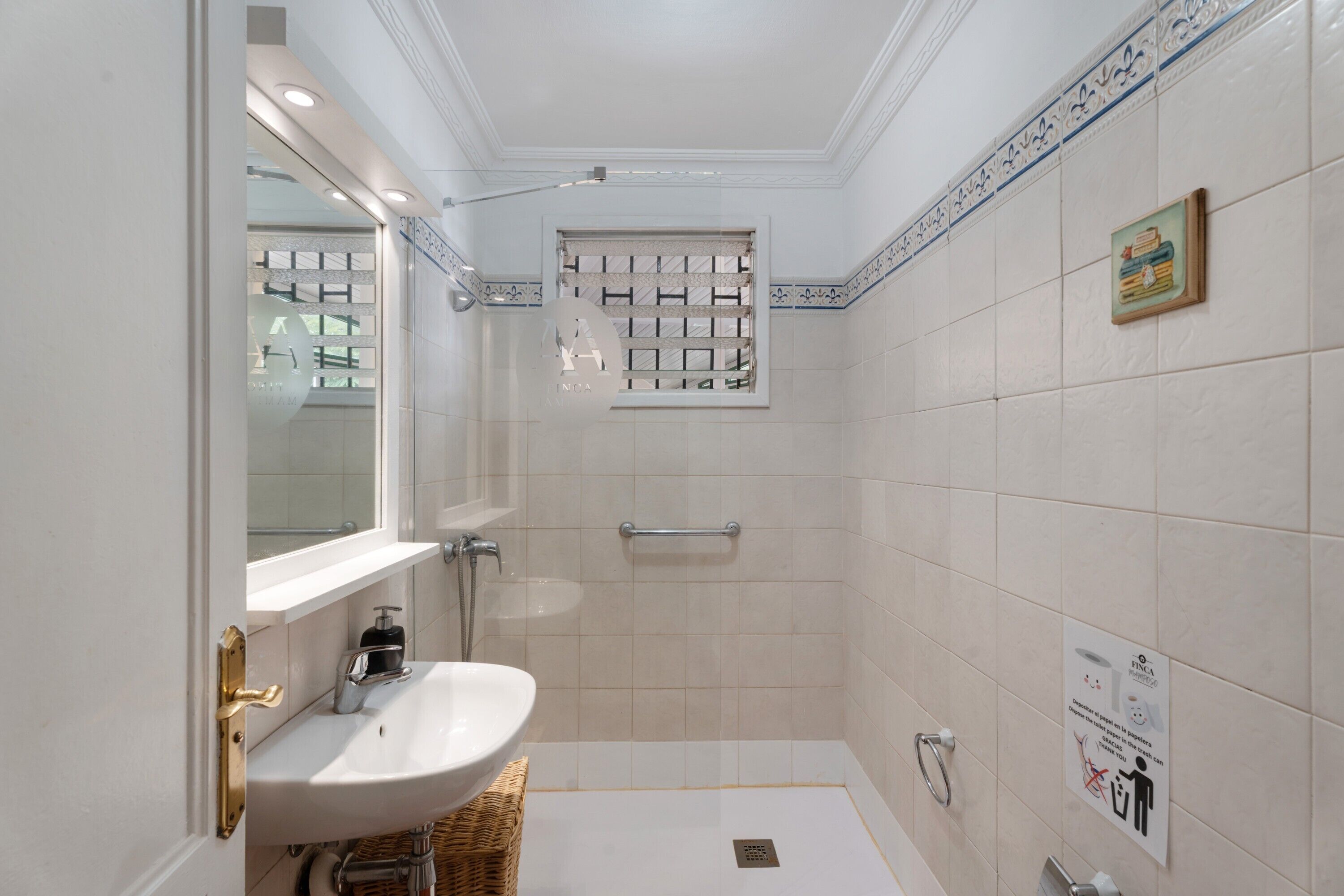 A bathroom with a sink, mirror, and shower.