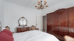 A bedroom with a large bed, a wooden wardrobe, a dresser, a mirror, and a chandelier. - Holiday Home 'Finca Mamposo' – Pets Welcome (Tacoronte)