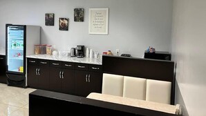 Una cocina moderna con refrigerador, cafetera y encimera con varios artículos.