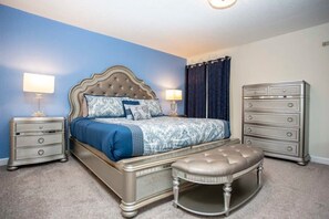 A bedroom with a bed, two bedside tables, a dresser, and an ottoman. - Home 6BR - Prime Location (Kissimmee)