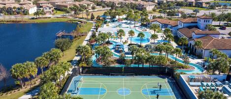 Zona residencial con una amplia piscina, canchas de tenis y un lago.