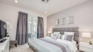 Ein modernes Hotelzimmer mit einem großen Bett, Nachttischen, einem Flachbildfernseher und einem Balkon mit Vorhängen.