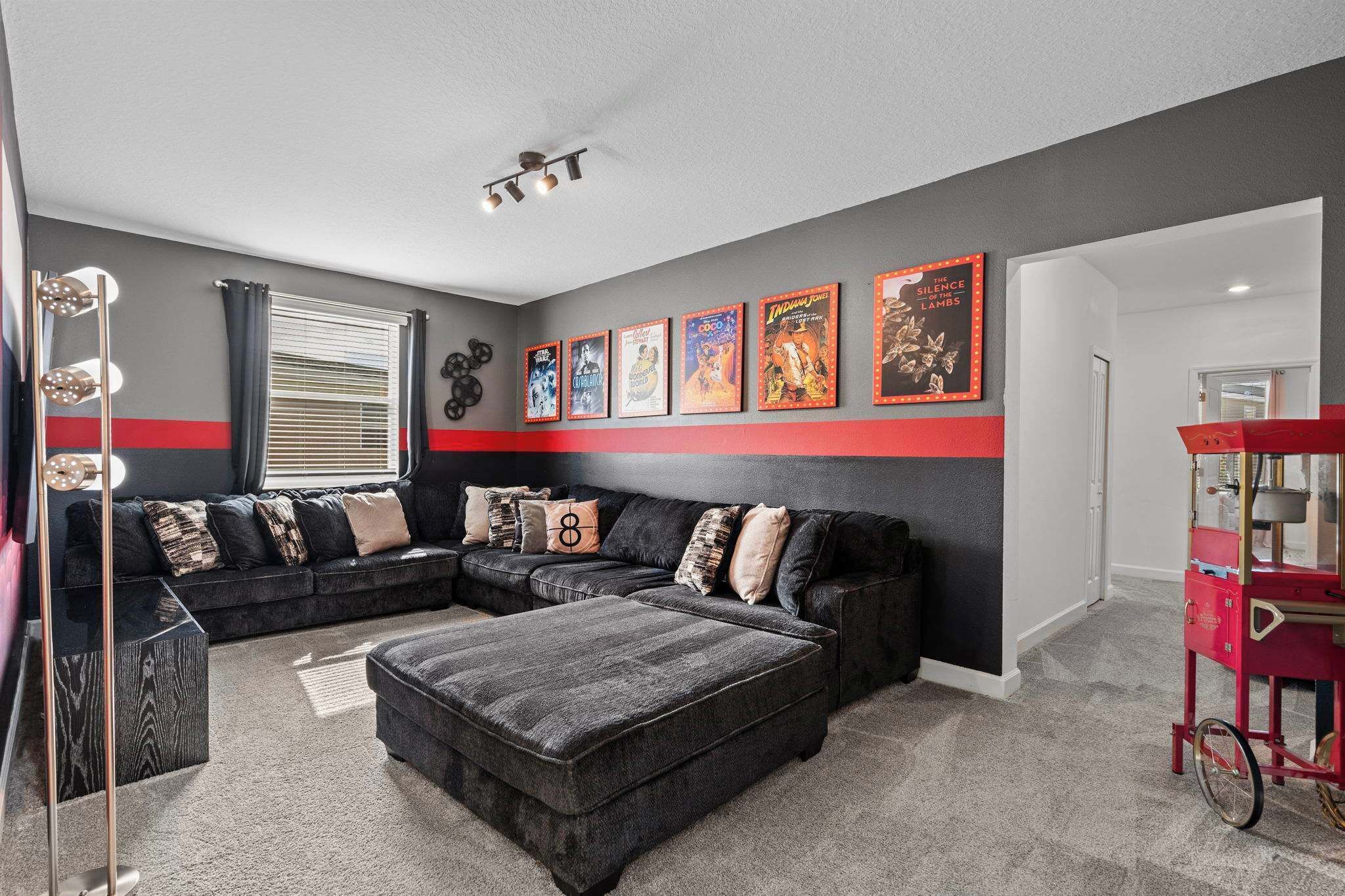 A modern living room with a sectional sofa, a coffee table, and a red cart.