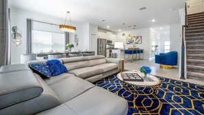 A modern living room with a sofa, coffee table, and a patterned rug. - Luxury Chic, Modern Home, Prime Location (Kissimmee)