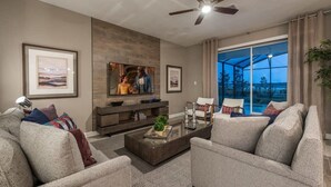 A modern living room with a sofa, coffee table, TV, and artwork on the wall. - Chic Luxury Haven - Unforgettable Retreat (Kissimmee)
