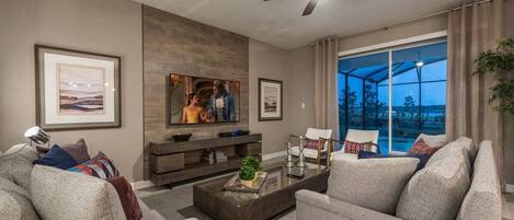 A modern living room with a sofa, coffee table, TV, and artwork on the wall.