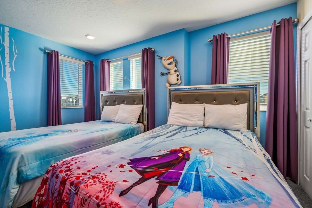 A hotel room with two beds, a large window with blinds, and a wall decoration.
