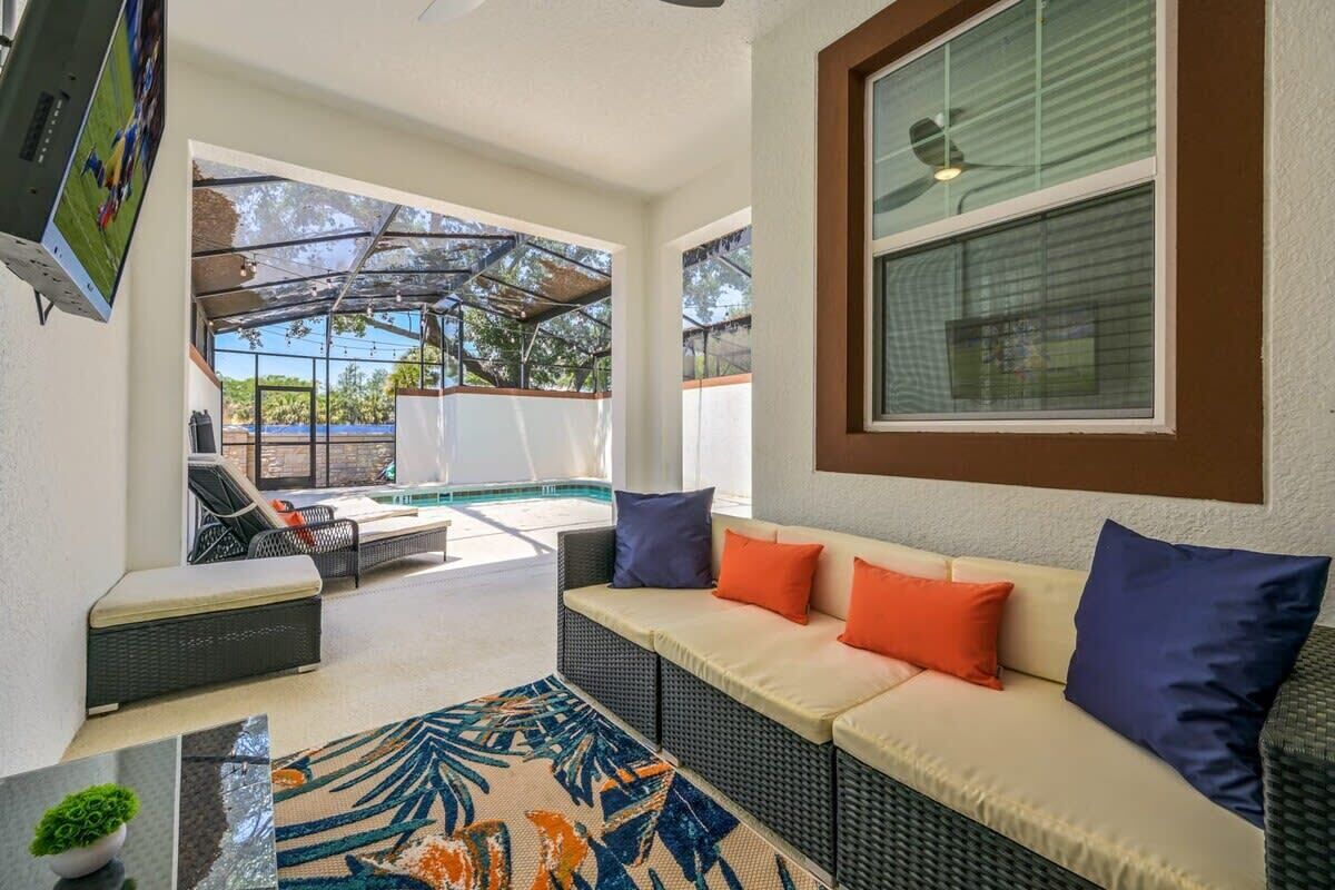 A covered outdoor seating area with a sofa, chairs, and a small table.