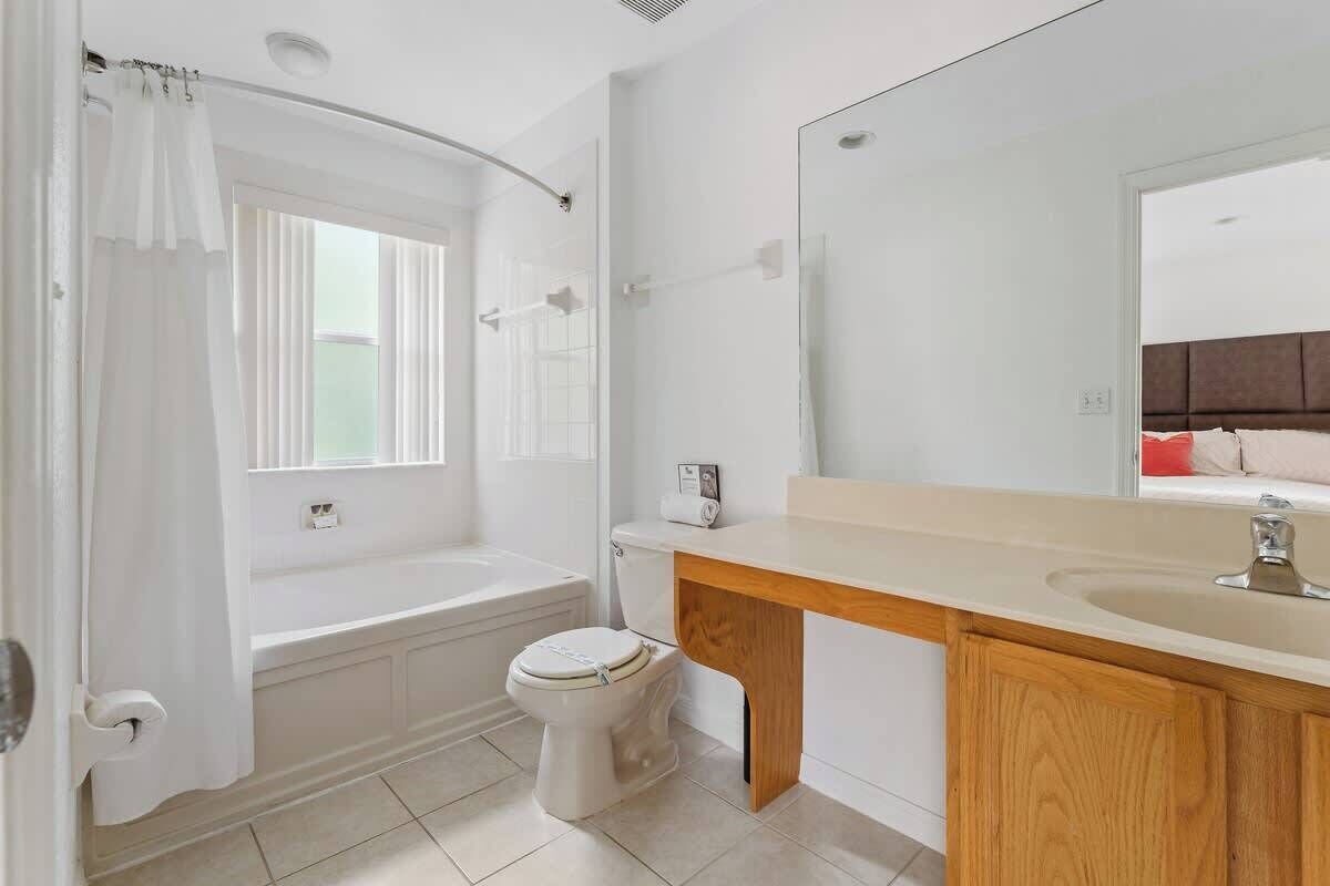 A modern bathroom with a bathtub, toilet, and vanity.