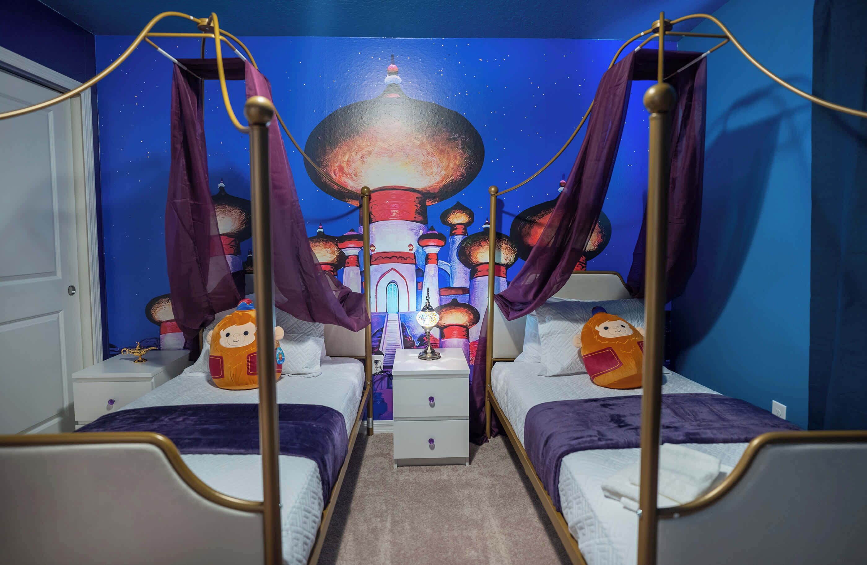 Une chambre avec deux lits, une table de chevet, une lampe et une fresque murale.