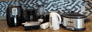 A kitchen with a coffee maker, blender, kettle, and slow cooker. - Lake View and Private Pool 4BR at Bella Vida (Kissimmee)