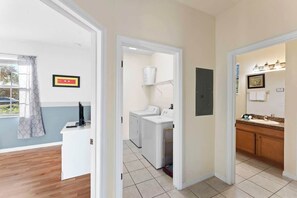A laundry area with washing machines, a drying rack, and a sink with a mirror. - Lake View and Private Pool 4BR at Bella Vida (Kissimmee)