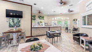 A hotel lobby with a reception desk, seating area, and a TV mounted on the wall. - Harry Potter Themed 3 BR (Kissimmee)