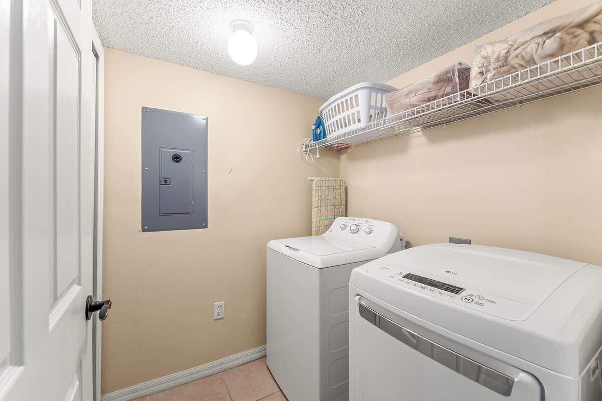 A laundry room with a washing machine, dryer, and a utility cabinet.