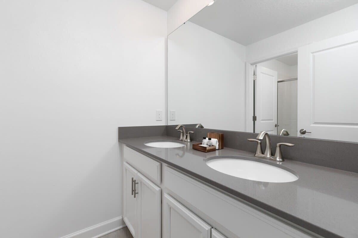 A bathroom with two sinks, a large mirror, and a cabinet.