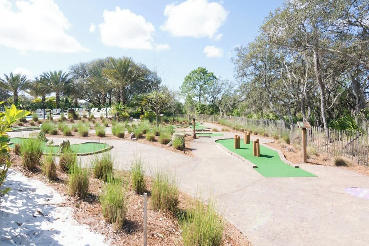 A golf course with a green fairway, sand bunkers, and a water hazard.