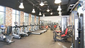 Ein Fitnessstudio mit Laufbändern, Crosstrainern und Kraftgeräten.