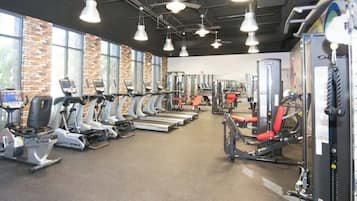 Un gimnasio con cintas de correr, elípticas y máquinas de pesas.