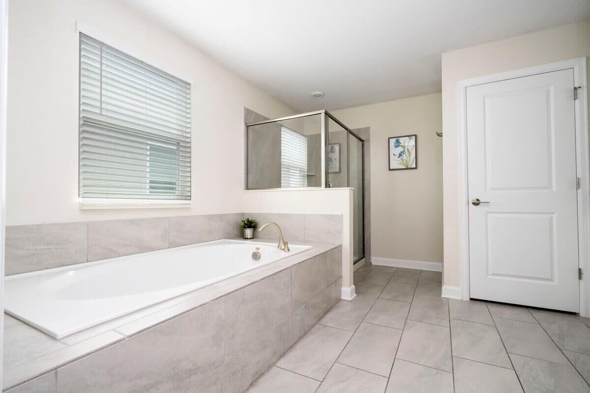Une salle de bain avec une baignoire, une douche et une porte.