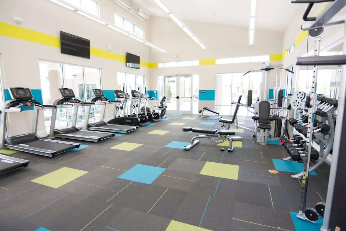 Een sportschool met loopbanden, krachtermaten en fitnessmatten.