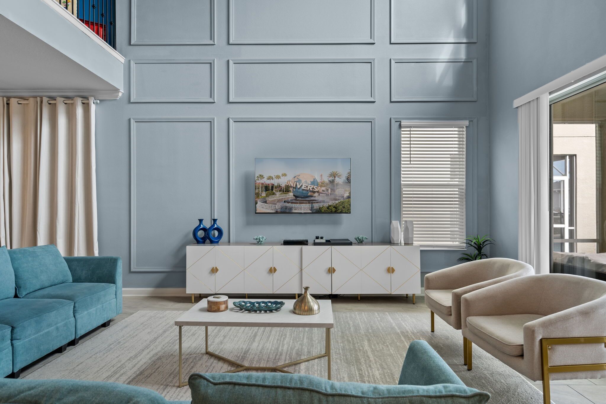 Een woonkamer met een witte kast, een smaragdgroene bank en beige fauteuils.