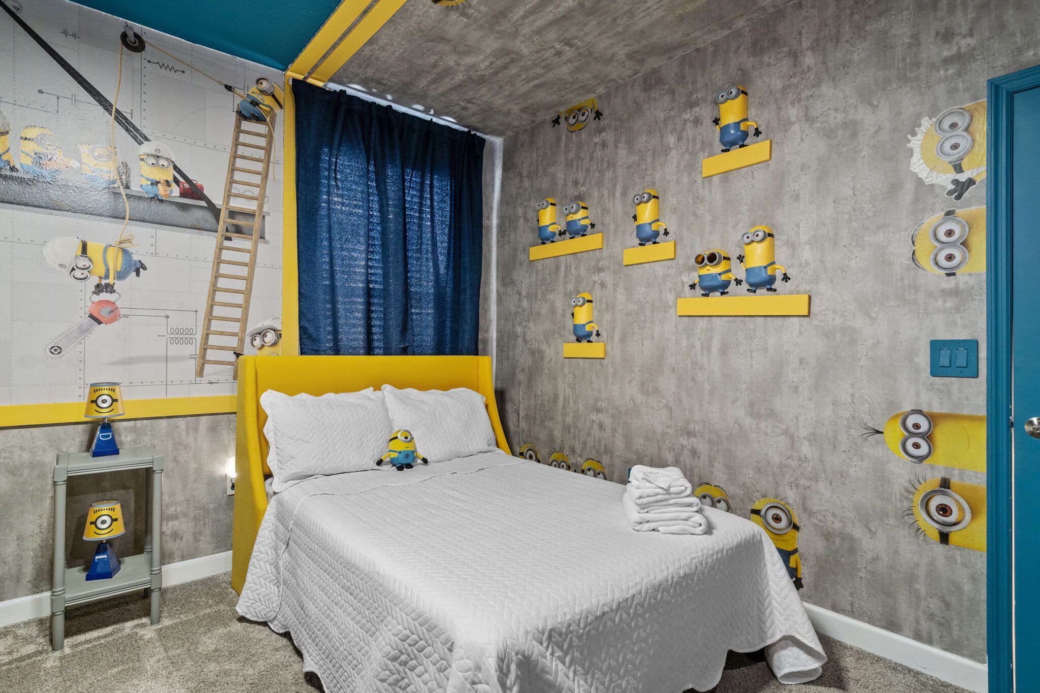 Ein Schlafzimmer mit Bett, Nachttisch, Kommode, einem Fenster mit Vorhängen und einer Wand mit Minion-Dekorationen.