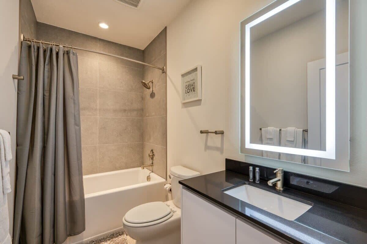 Un bagno moderno con vasca, water e lavandino.