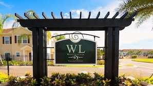 Schild für das West Lucaya Village Resort mit einer Pergola.