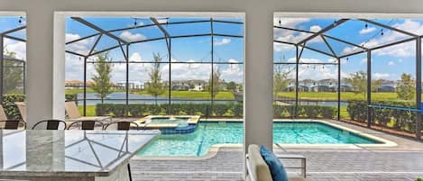 A covered outdoor area with a pool, seating, and a clear view of the surrounding landscape.