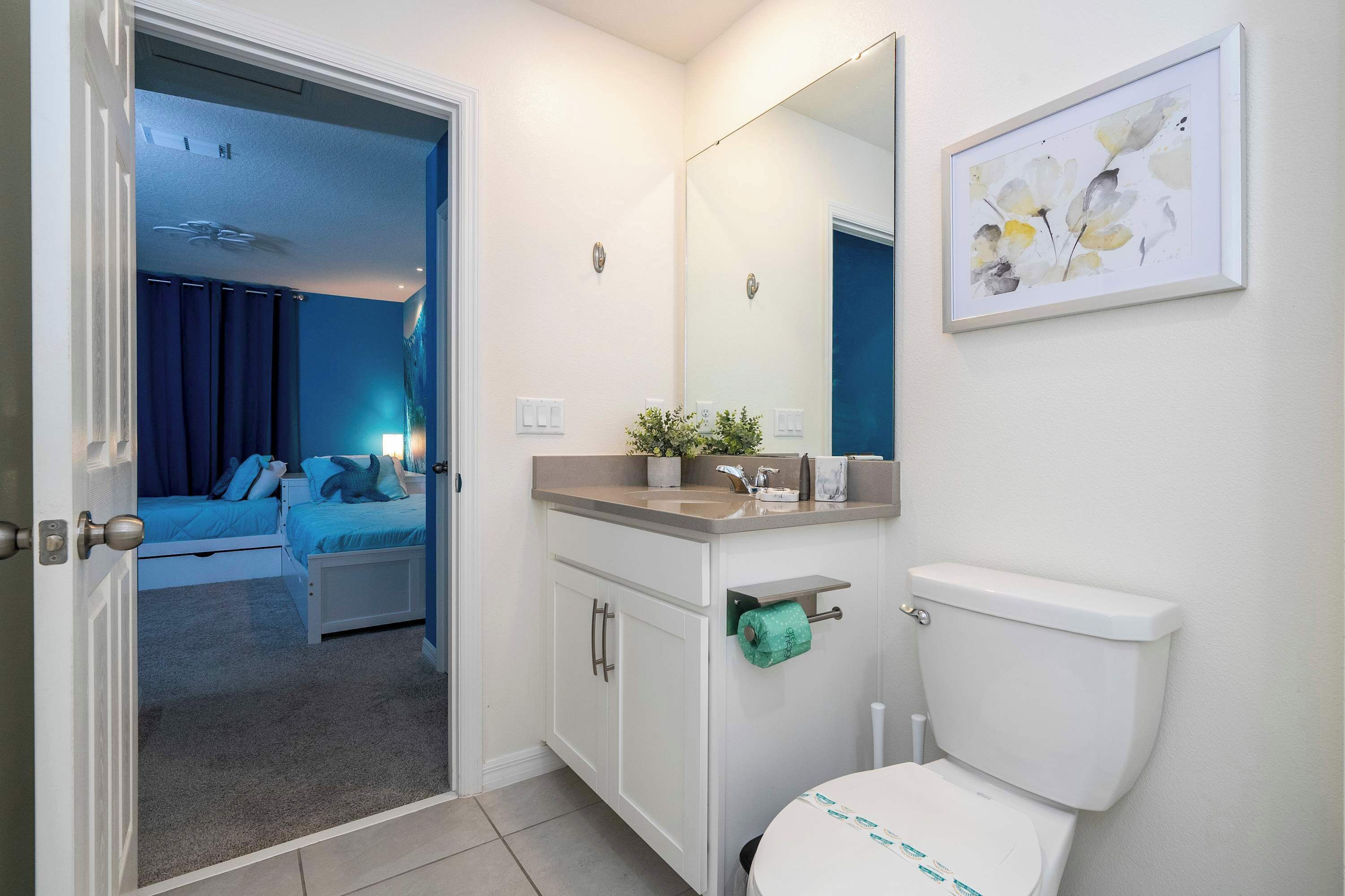 Une salle de bain avec des toilettes, un lavabo et un miroir.