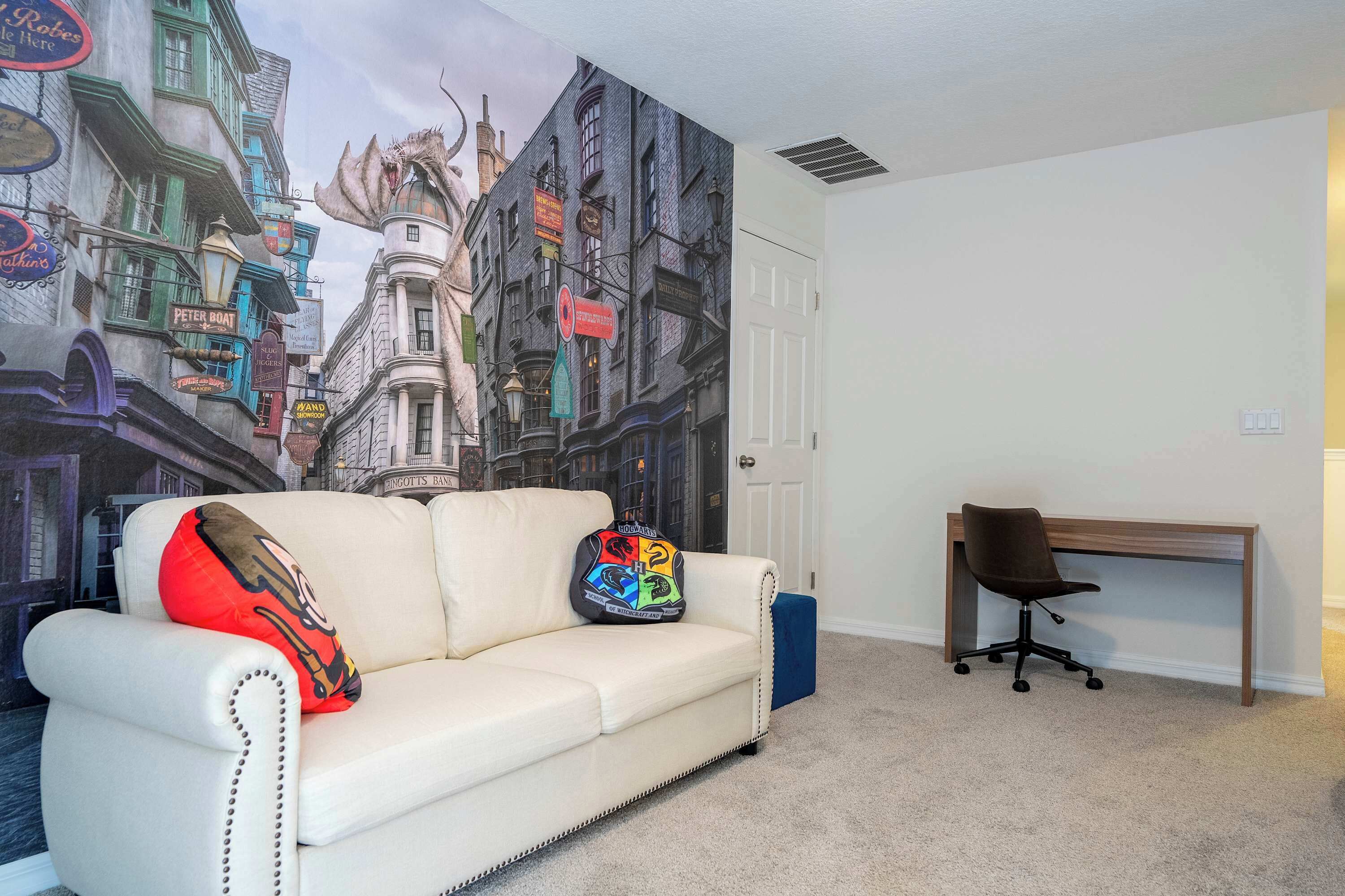 Une pièce avec un canapé en cuir blanc, un bureau et une fresque murale.