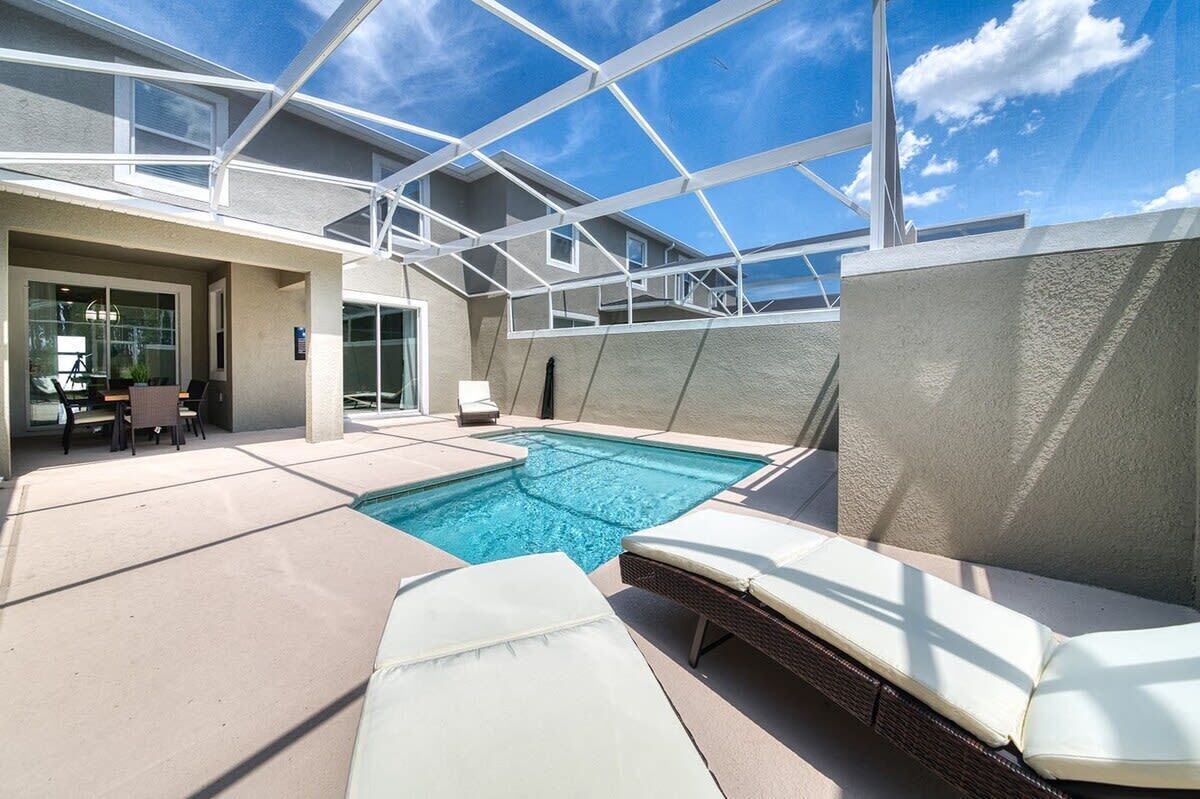 Ein Pool auf dem Dach mit Liegestühlen, einer überdachten Terrasse und blauem Himmel.