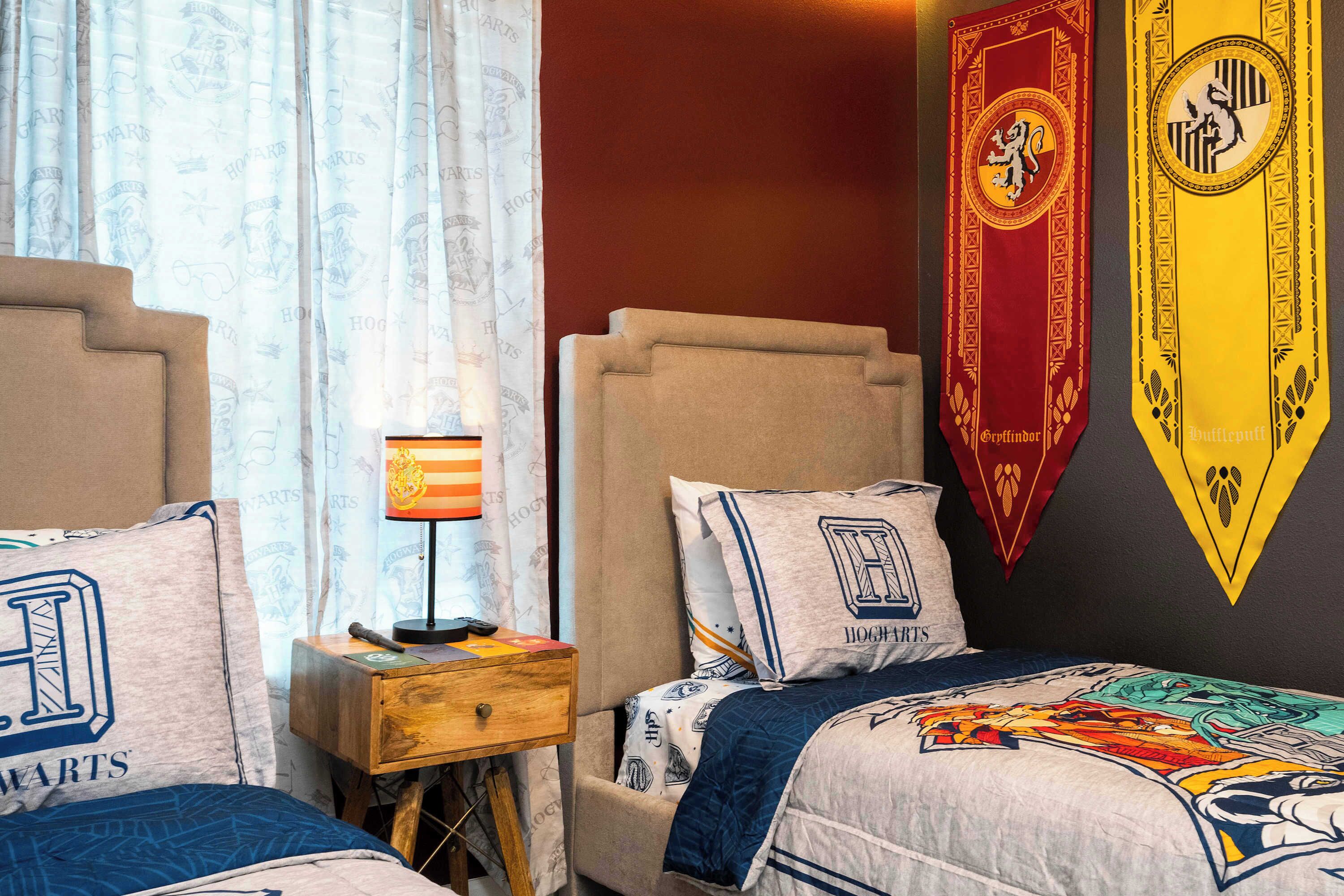 Une chambre à coucher avec un lit, une table de chevet, une lampe et deux bannières accrochées au mur.