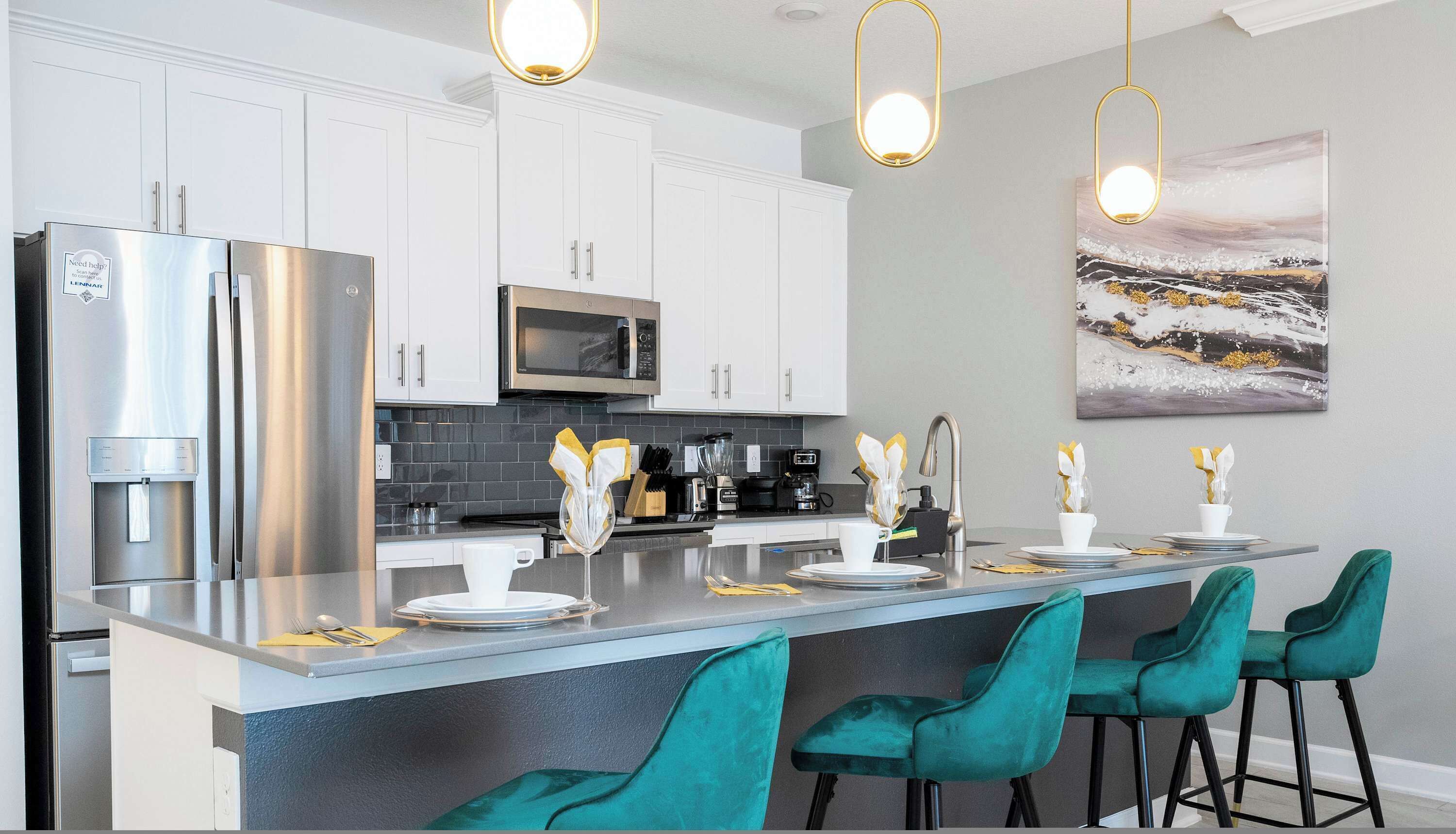 A modern kitchen with stainless steel appliances, a central island with bar stools, and a minimalist design.