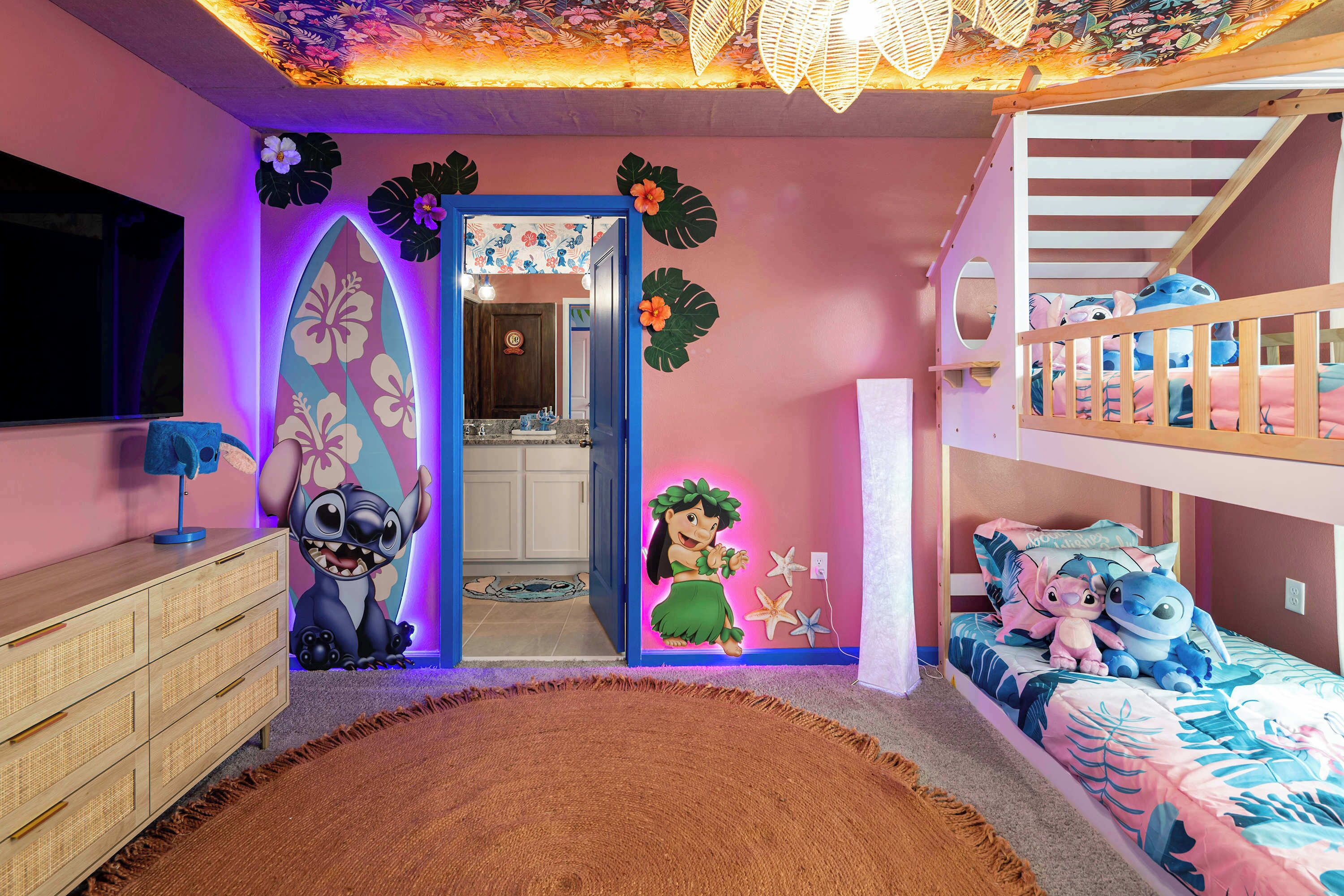 A child's room with a bunk bed, a dresser, a surfboard decoration, and a cartoon character wall mural.
