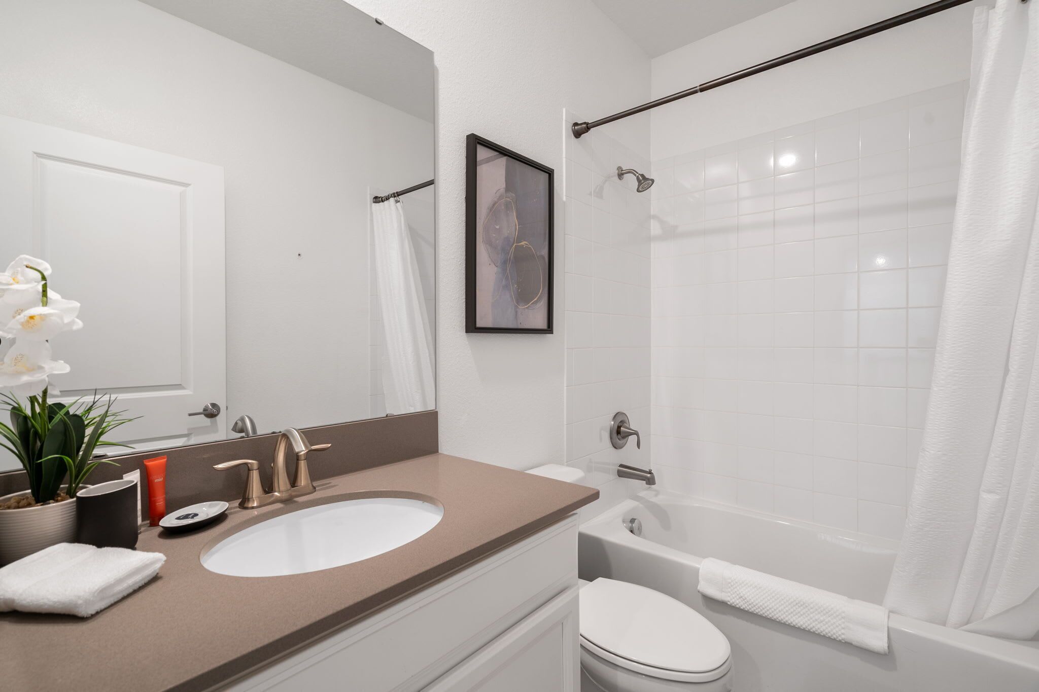 A bathroom with a sink, toilet, and bathtub.