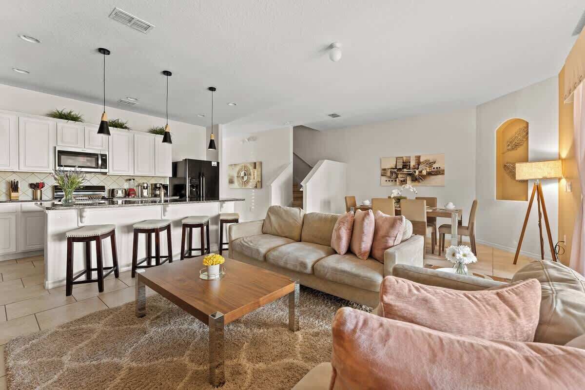 A modern kitchen with white cabinets, a central island, and pendant lighting.