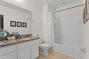 Et moderne badeværelse med bruser, toilet og håndvask.