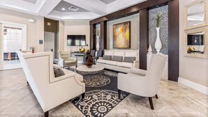 A spacious living room with a modern design, featuring a large sofa set, a coffee table, and a decorative rug. - Private Pool at Solterra 4BR Townhome (Davenport)